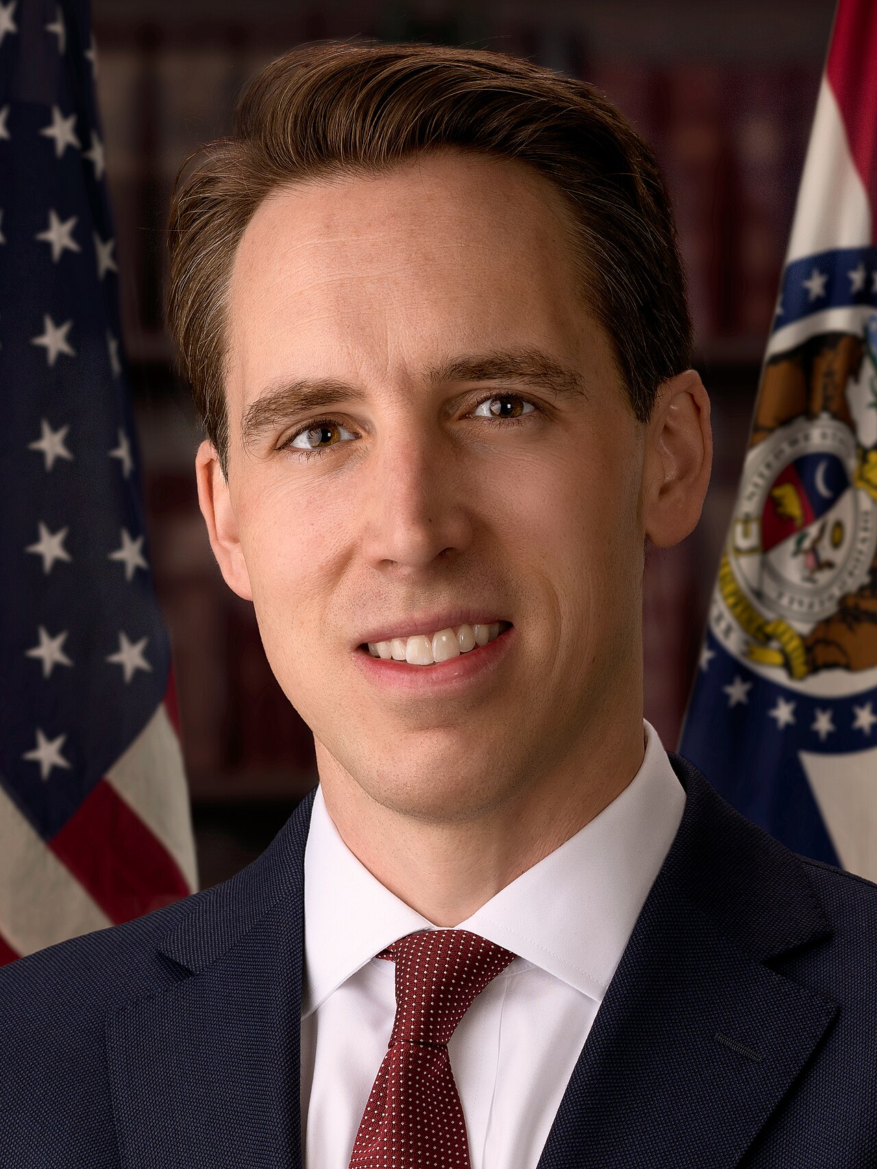 Official Senate portrait of Senator Josh Hawley of Missouri in front of US and Missouri flags