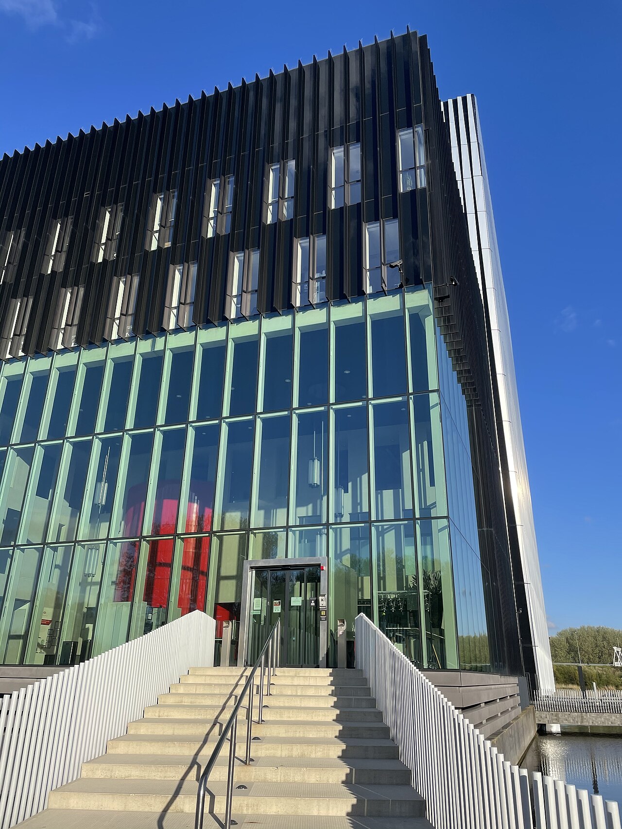 Glass and metal entrance of the Equinix data center building in Amsterdam under a blue sky