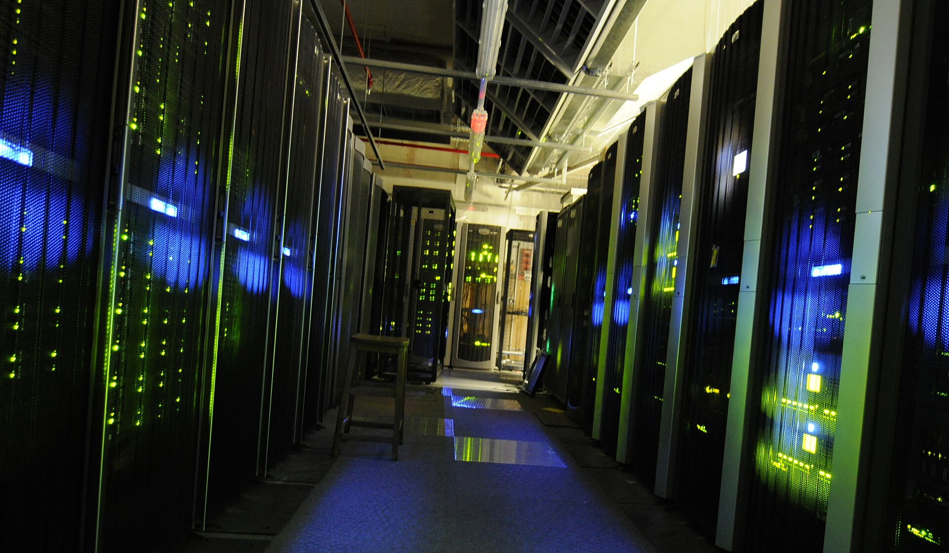 Rows of server racks with blinking lights in a data center corridor