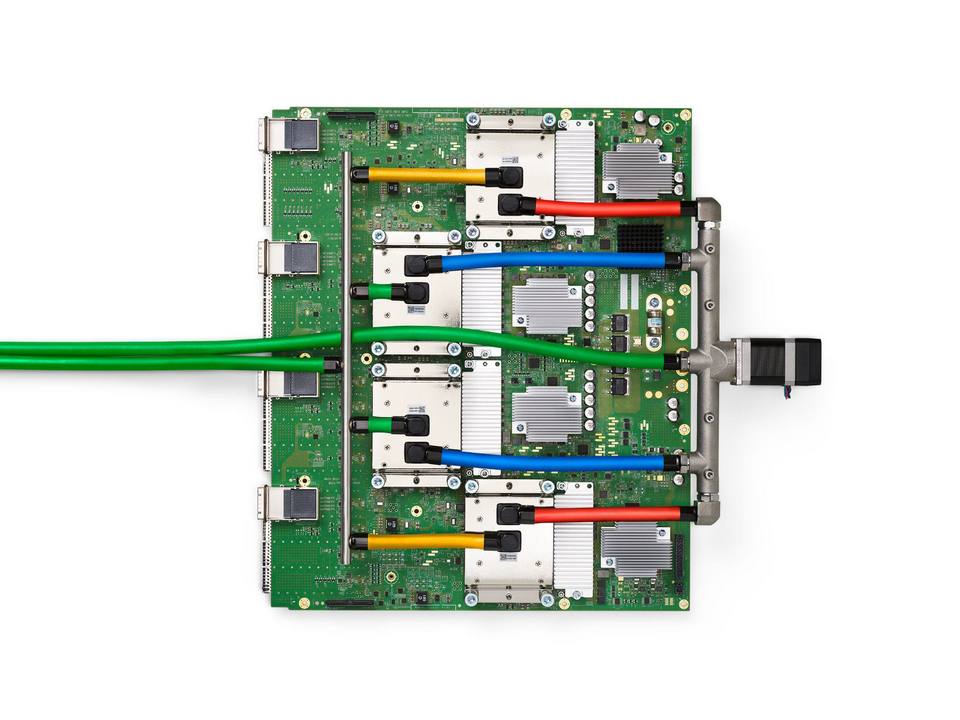 A Google TPU v4 board showing four accelerator modules with coloured liquid cooling lines