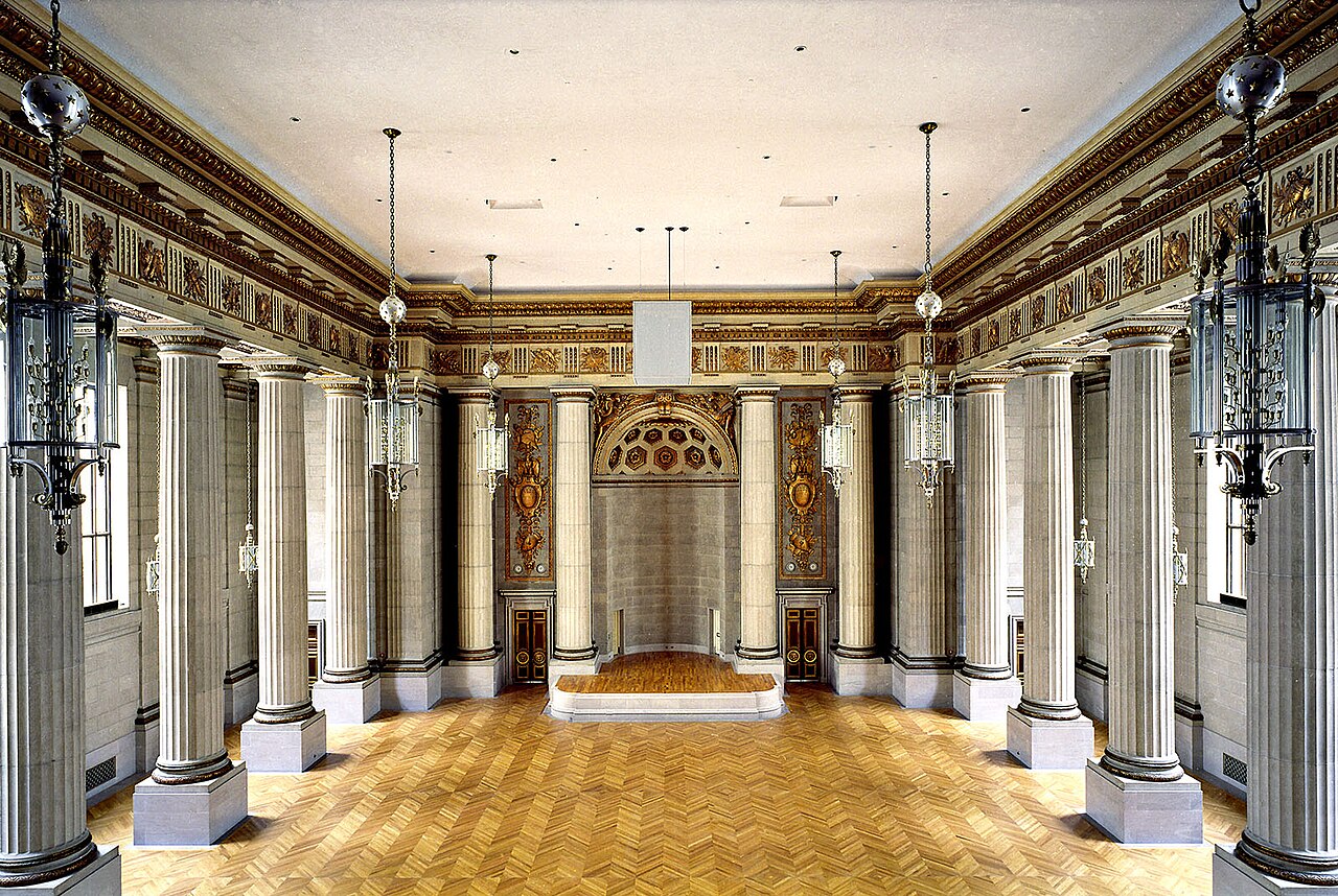 Interior of the Andrew W. Mellon Auditorium in Washington, D.C., seen from the rear balcony toward the stage