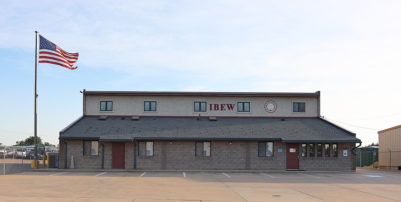 Exterior of an International Brotherhood of Electrical Workers Local No. 12 union hall building in Pueblo, Colorado, with an American flag and IBEW signage