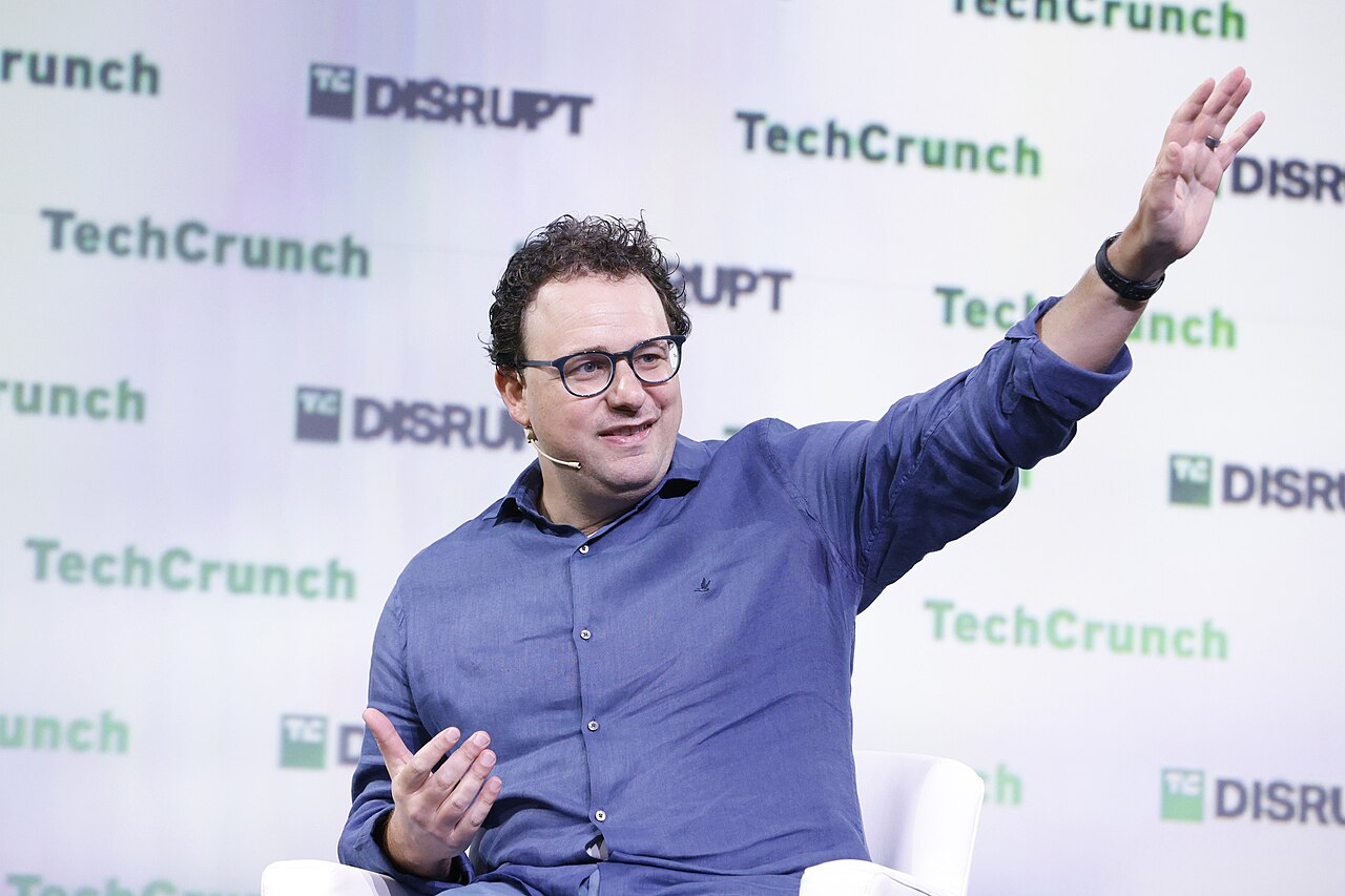 Dario Amodei, CEO of Anthropic, gesturing while speaking on stage at TechCrunch Disrupt 2023