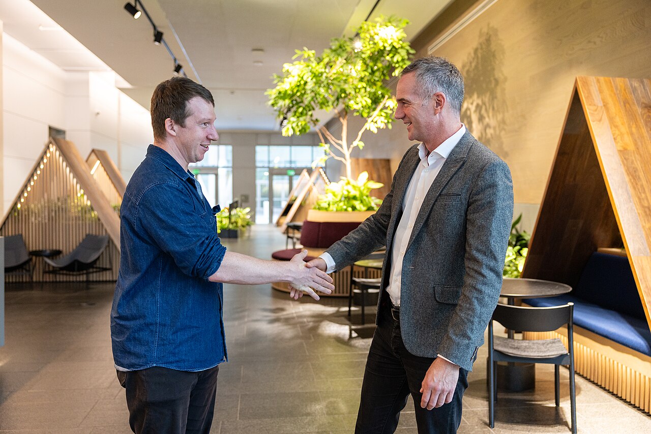 Two men shaking hands in the lobby of Anthropic's San Francisco office