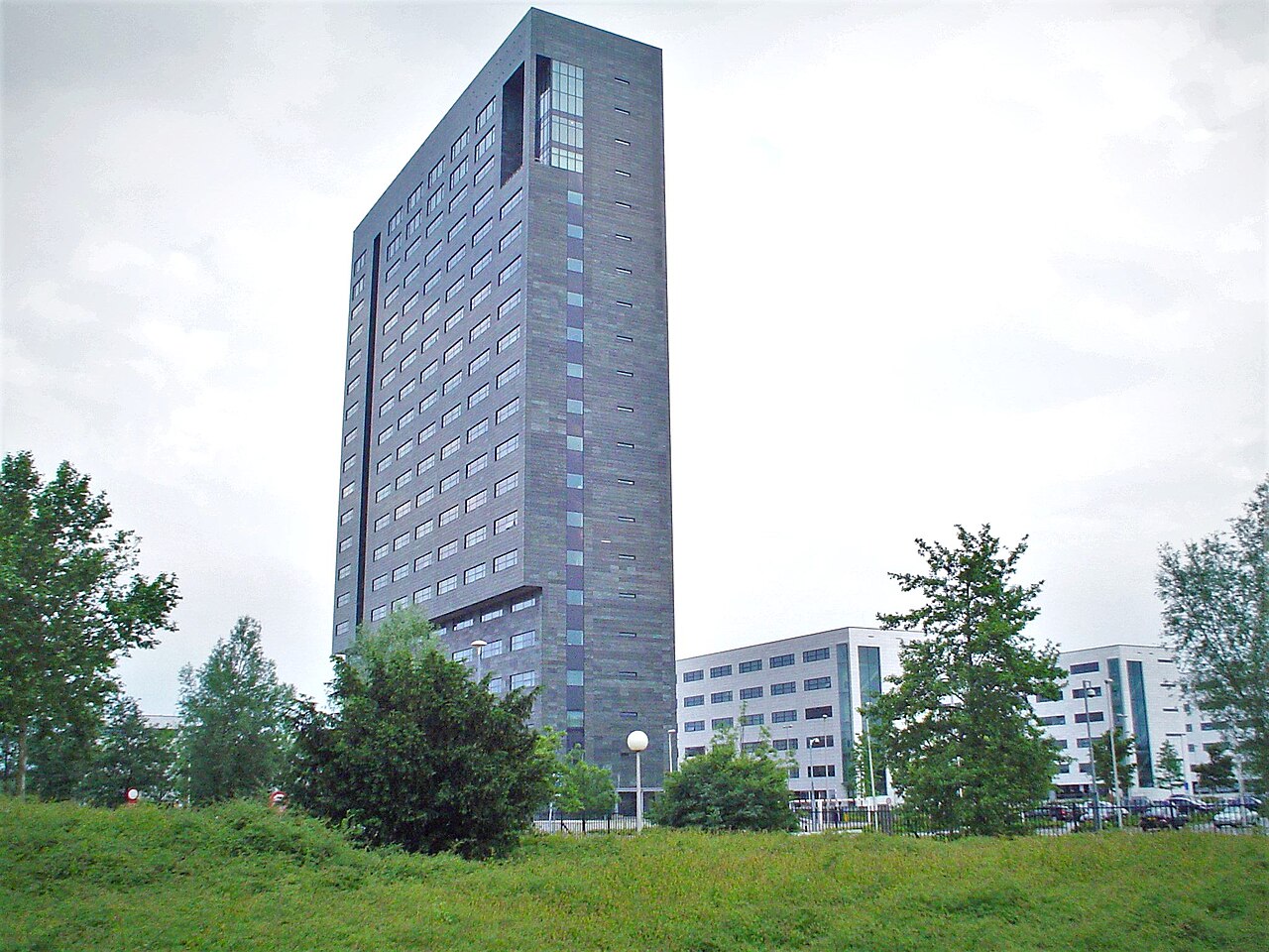 ASML headquarters office tower in Veldhoven, Netherlands, with lower white buildings beside it