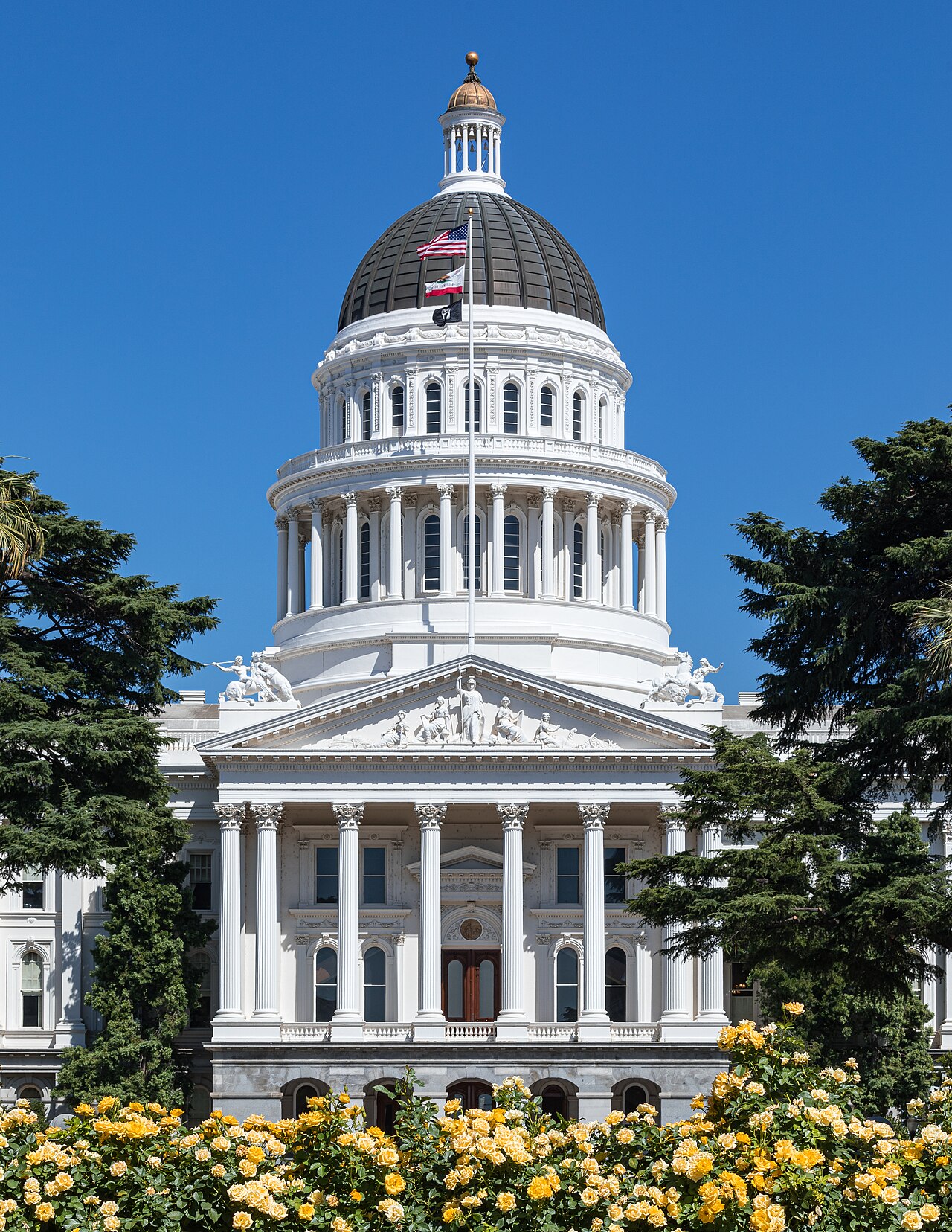 The full front facade and rose garden of the California State Capitol building in Sacramento