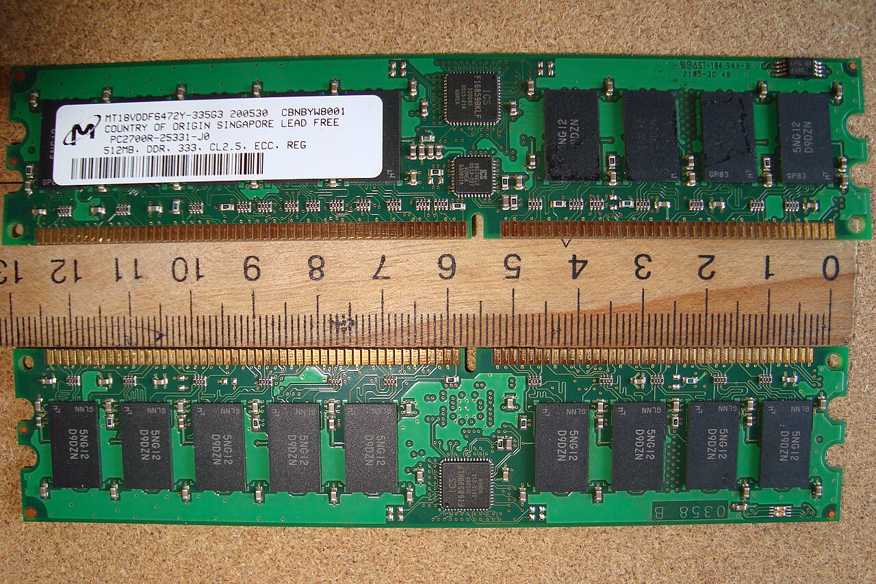 Two registered ECC DRAM server memory modules laid against a ruler for scale