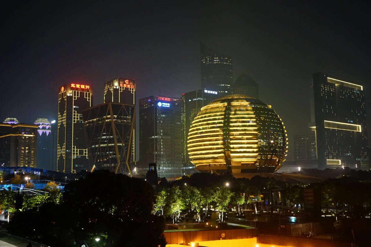 Night view of towers and a lit spherical building in Qianjiang New City, Hangzhou