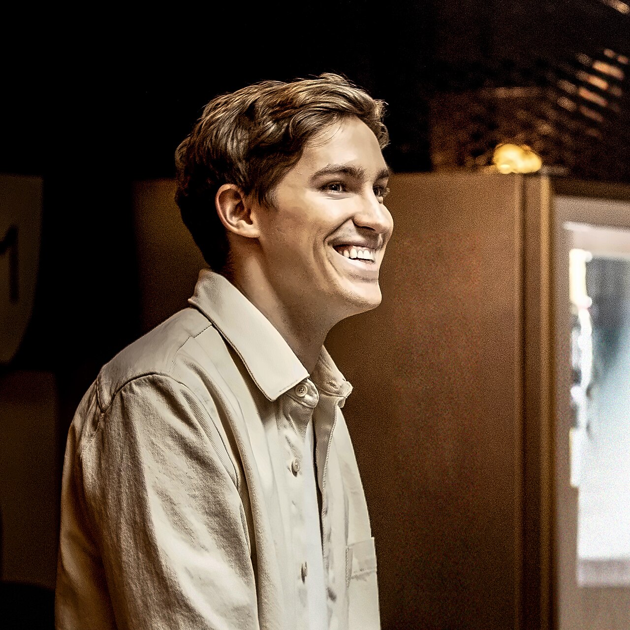Portrait of Mati Staniszewski, co-founder of ElevenLabs, smiling in a dimly lit room