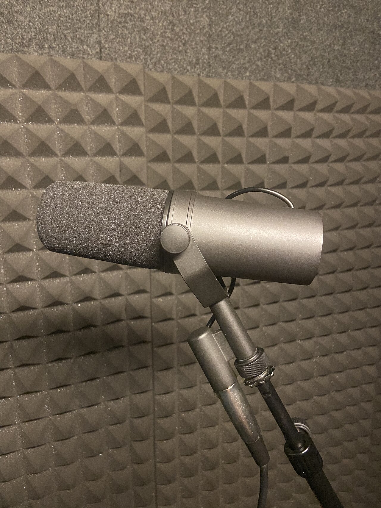 A Shure SM7 dynamic microphone mounted in front of acoustic foam panels