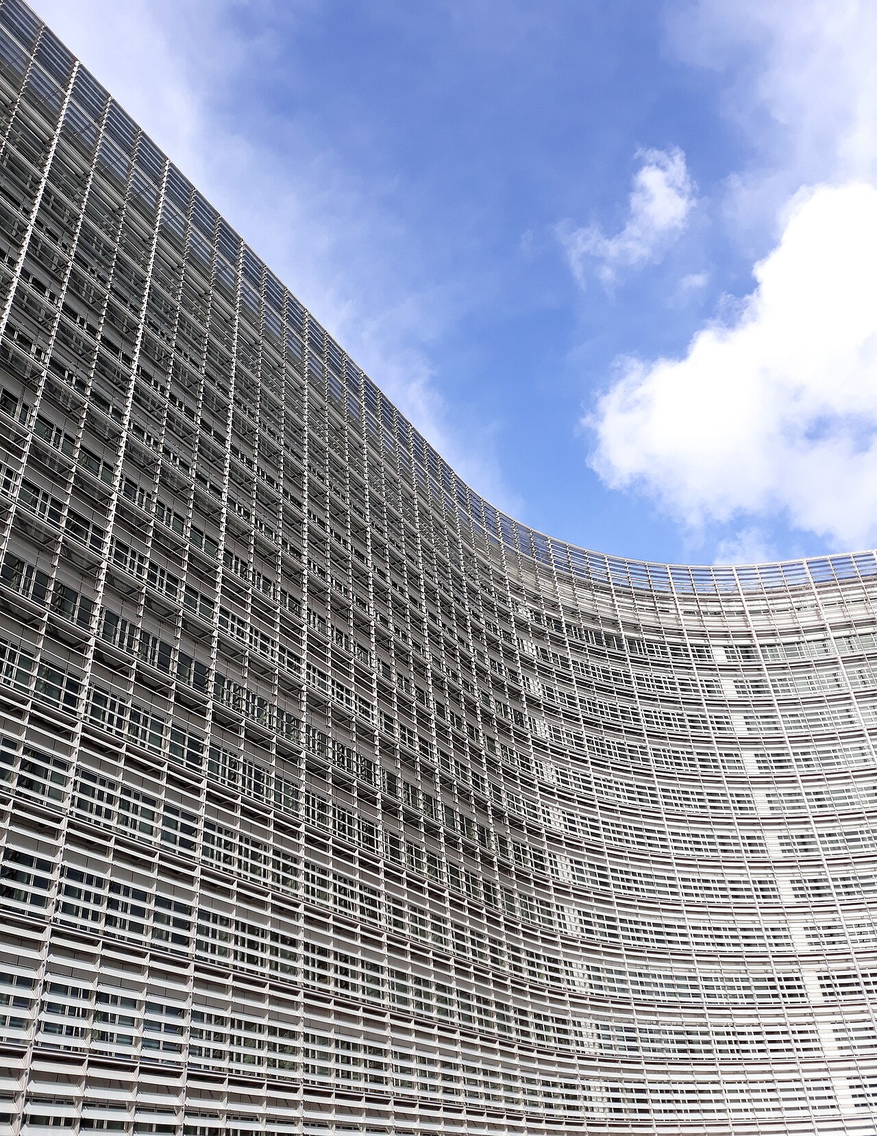 Upward view of the curved glass and steel facade of the Berlaymont building in Brussels
