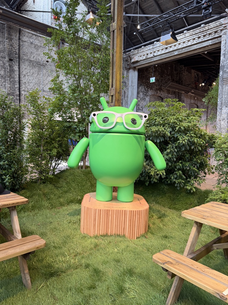 A large green Android robot mascot on display at a Google developer event