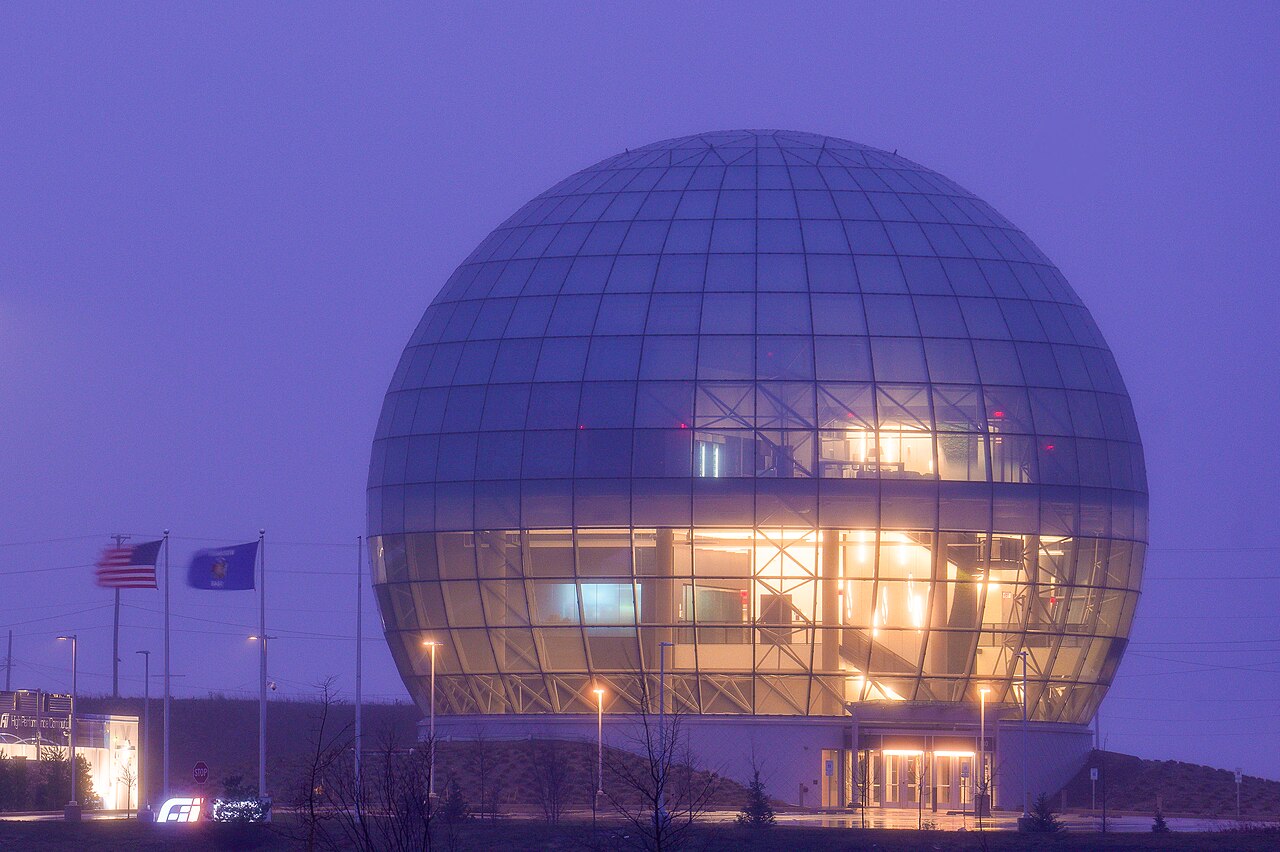 A large glowing spherical glass building at dusk, Foxconn's globe structure at its Mount Pleasant, Wisconsin campus
