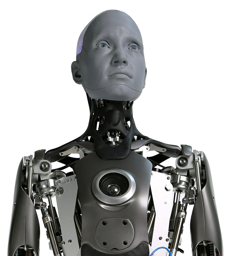 Close-up of a grey-faced humanoid robot with an exposed mechanical torso, looking upward