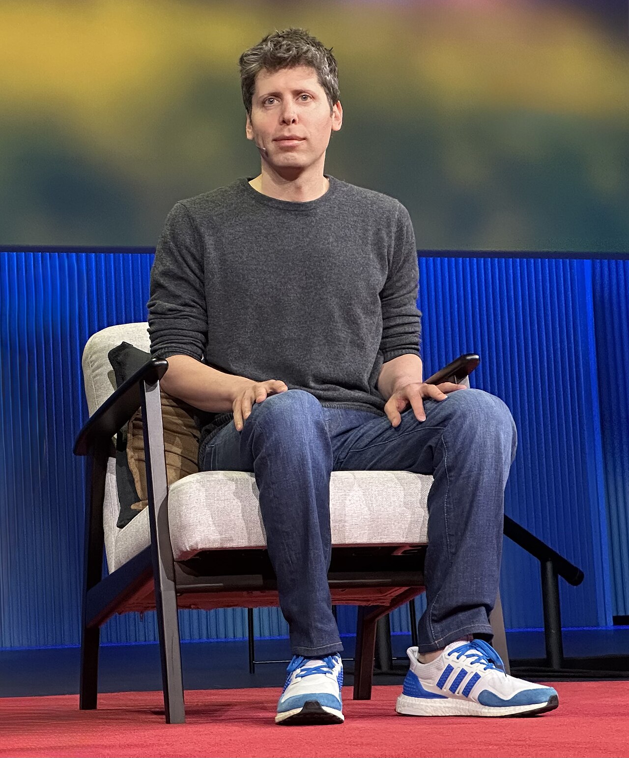 Sam Altman seated on a TED stage wearing a headset microphone