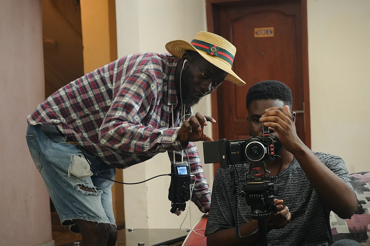 Two filmmakers operating a cinema camera during a video shoot
