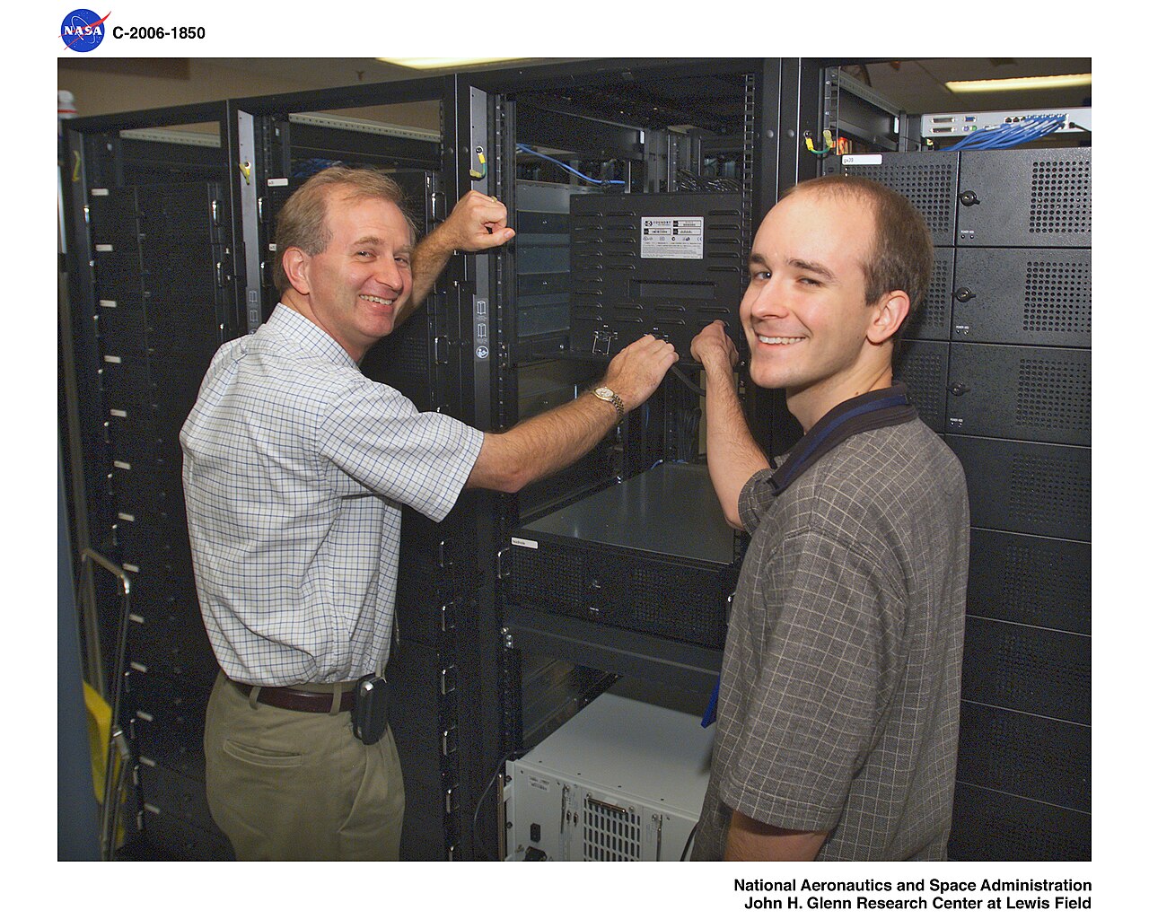 Two engineers inspecting the cabling and rack-mounted servers of a compute cluster