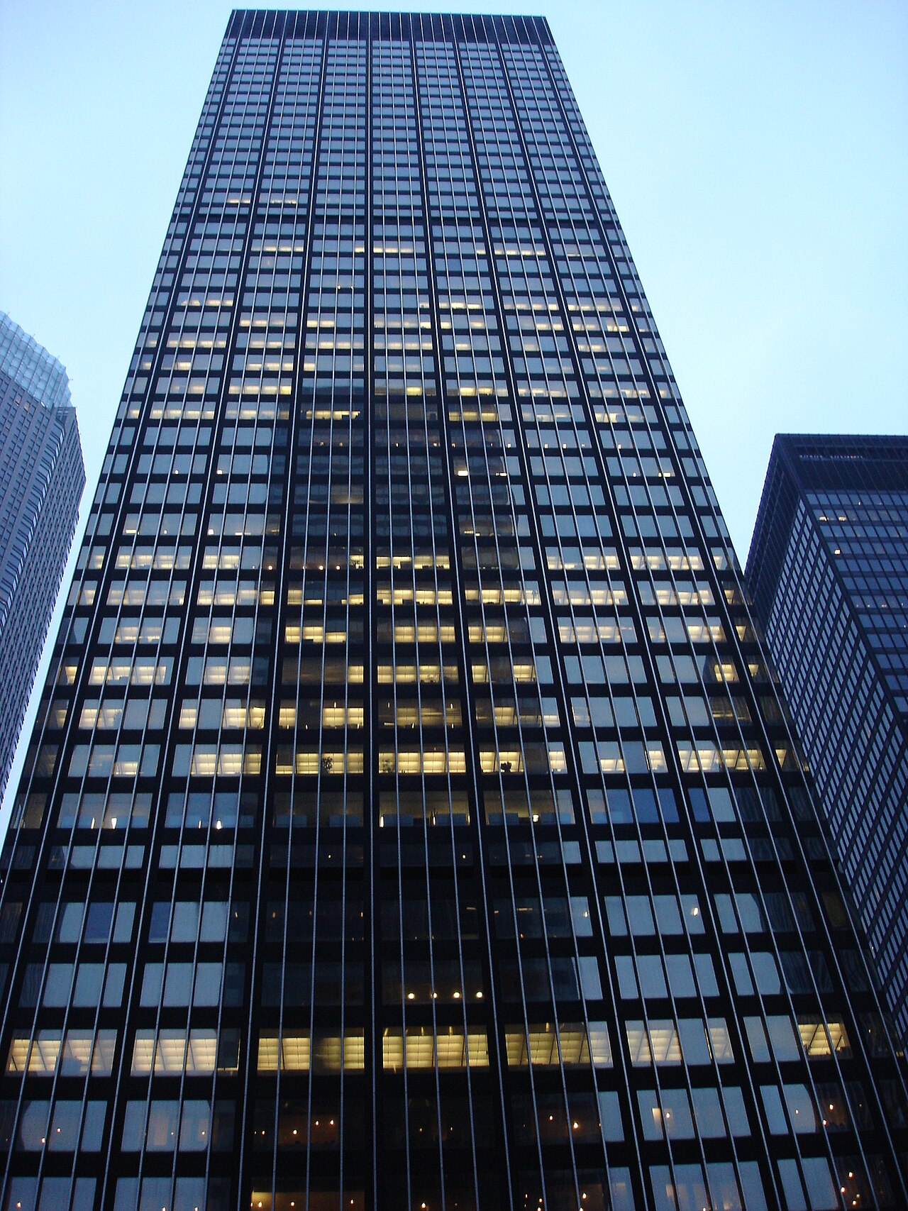Looking up at a dark glass and steel skyscraper at dusk, the former JPMorgan Chase headquarters at 270 Park Avenue in Manhattan
