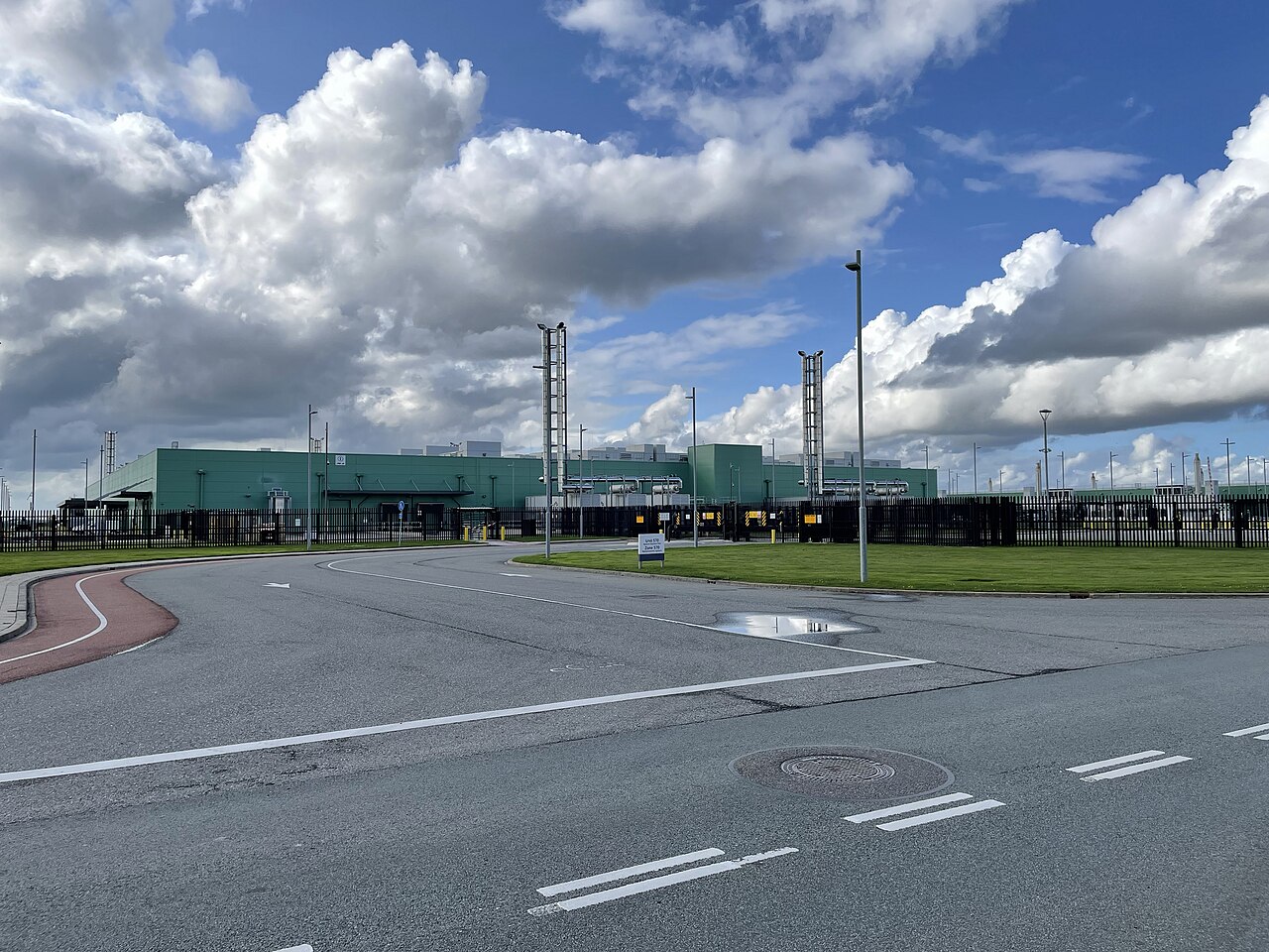 Exterior of a Microsoft data center campus in Middenmeer, the Netherlands, showing a fenced perimeter and modular data hall buildings