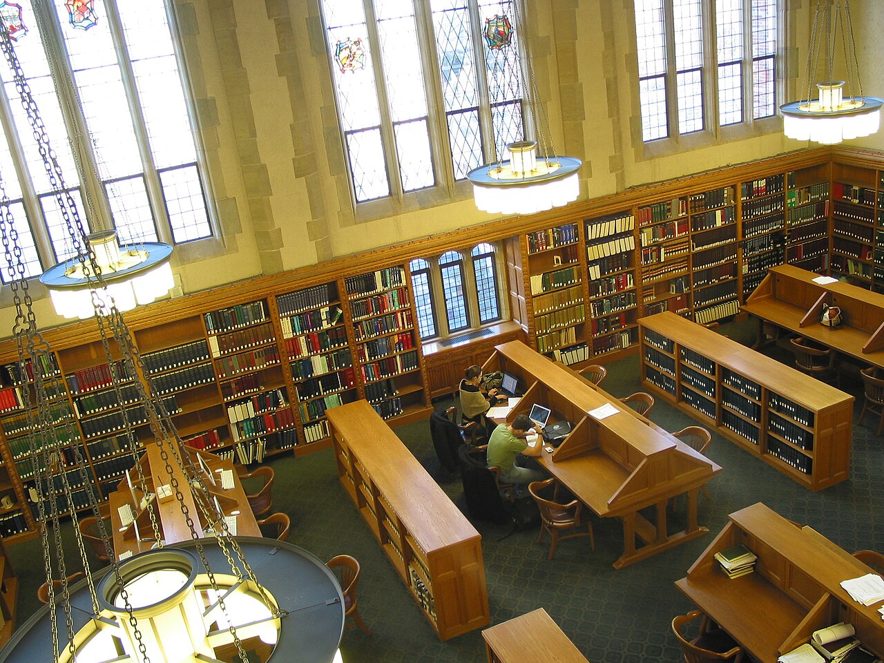 Students working with laptops in the wood-paneled reading room of the Yale Law School library