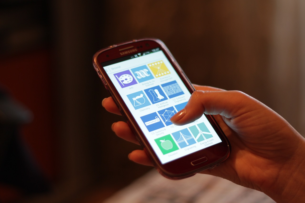 A person tapping an app grid on a smartphone