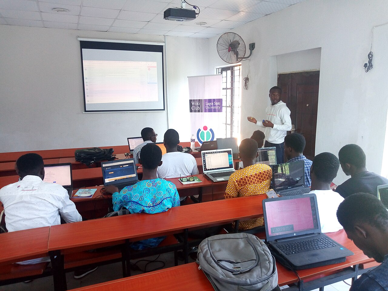 Developers working on laptops writing and reviewing code at a coding meetup