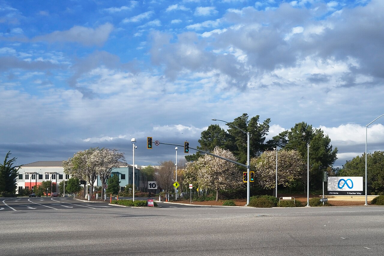 Meta Platforms headquarters entrance sign reading Meta, 1 Hacker Way, in Menlo Park, California, with the infinity logo