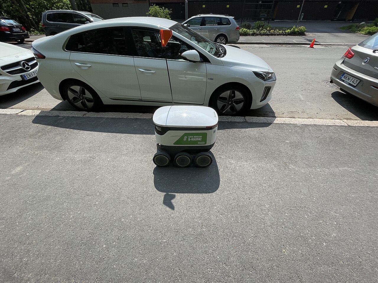 A small autonomous sidewalk delivery robot crossing a street in Finland