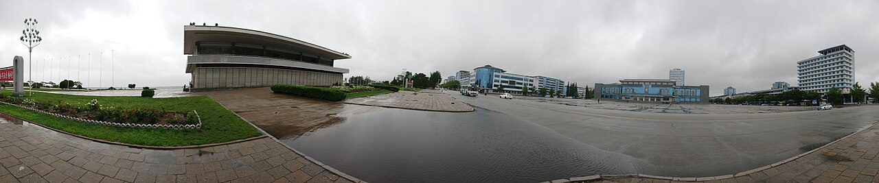 Panoramic view of a public square and buildings in Wonsan, North Korea, under an overcast sky