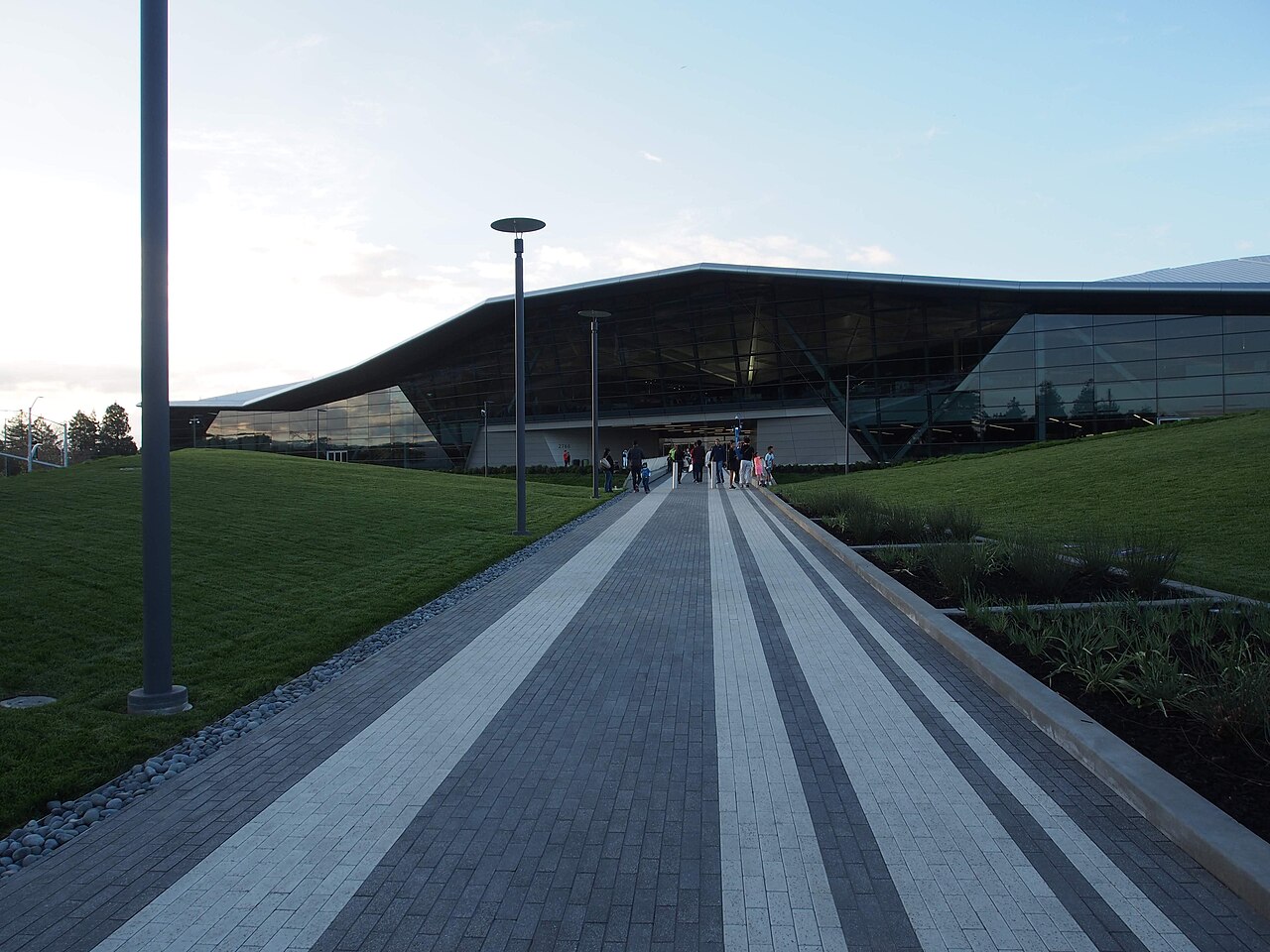 The entrance walkway to Nvidia's Endeavor headquarters building in Santa Clara, California, with visitors approaching at dusk