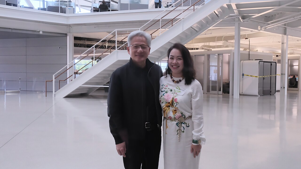 NVIDIA founder and CEO Jensen Huang standing indoors at a company facility with a visitor