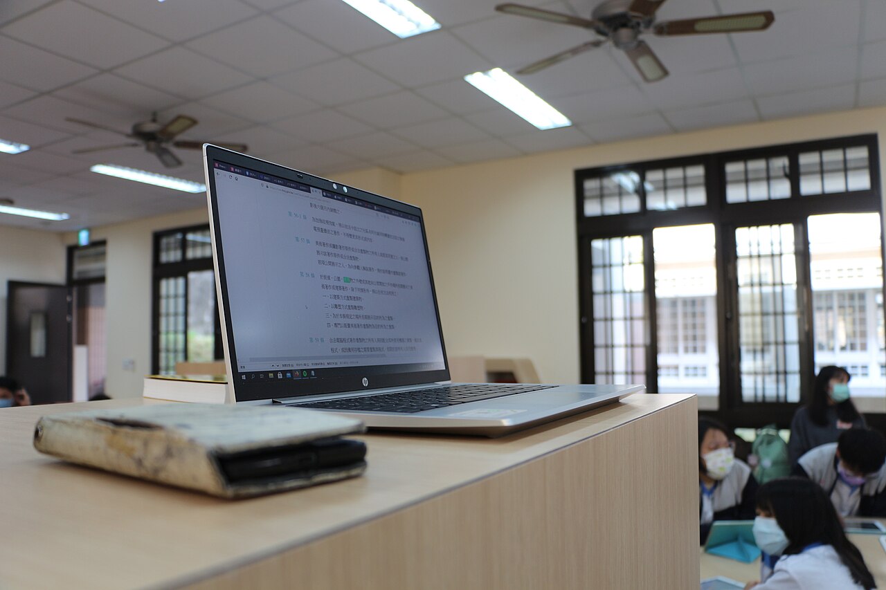 Students using a laptop in a classroom setting