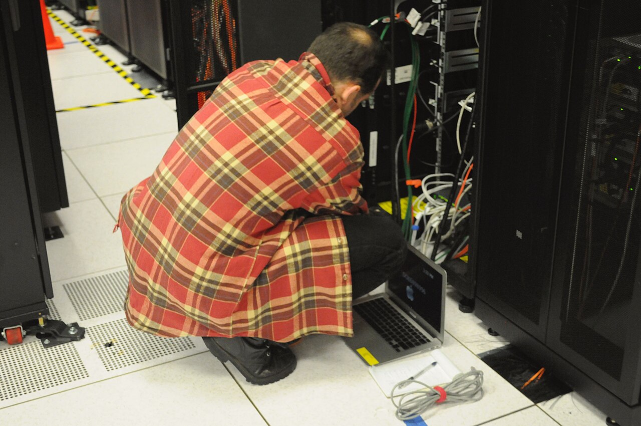 A technician working on a server rack inside a data center