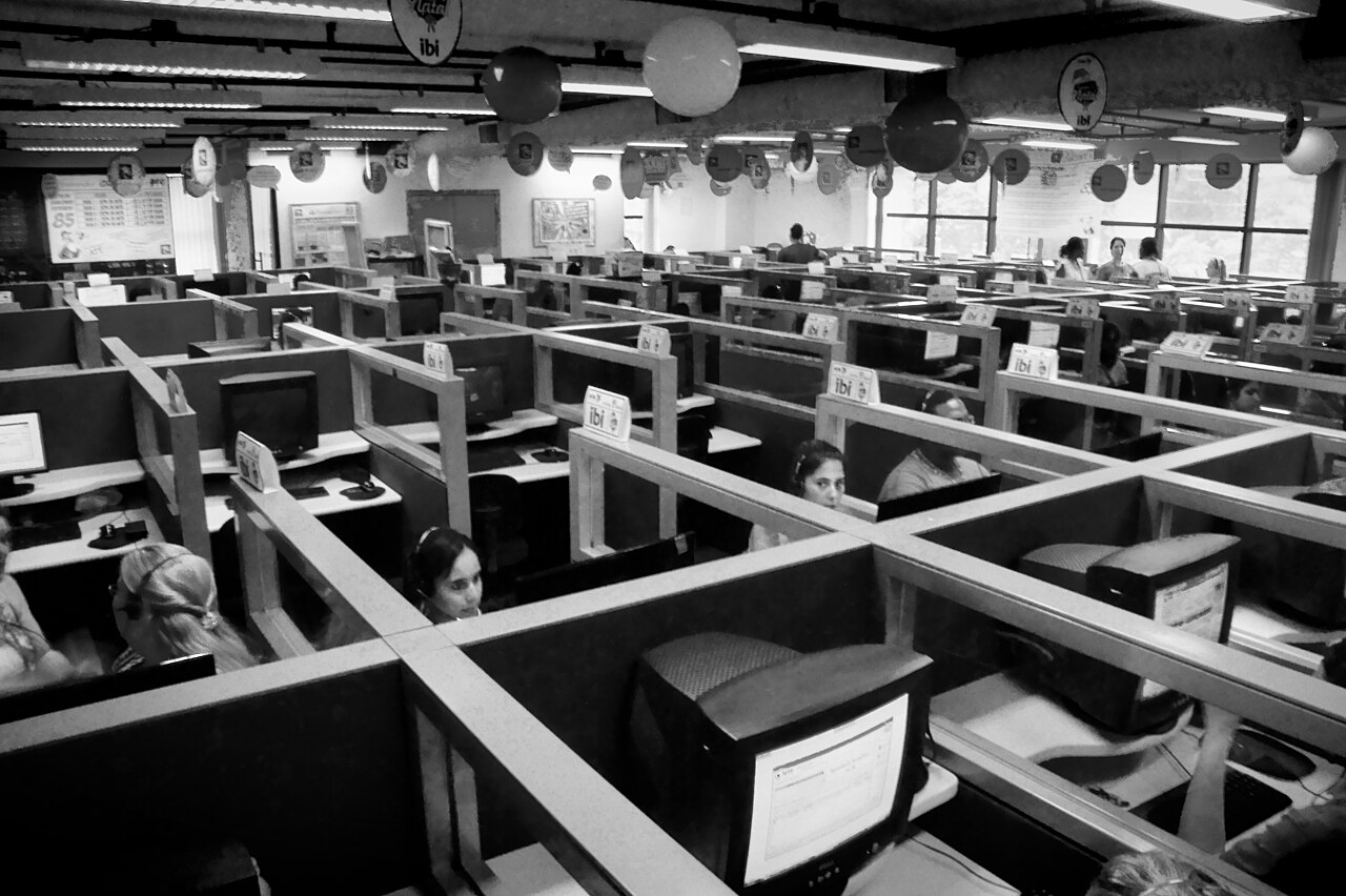 Rows of cubicles with headset-wearing agents at a traditional human-staffed call center