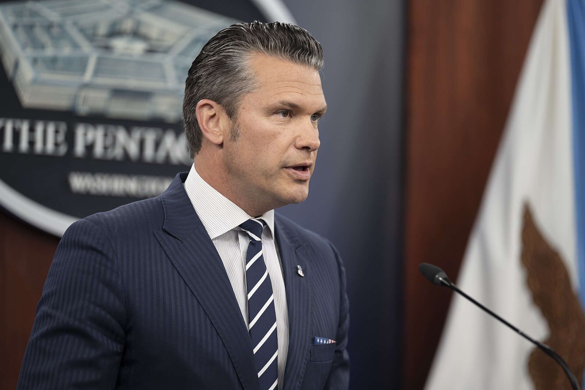 Then-Secretary of Defense Pete Hegseth speaking at a Pentagon press briefing podium in June 2025