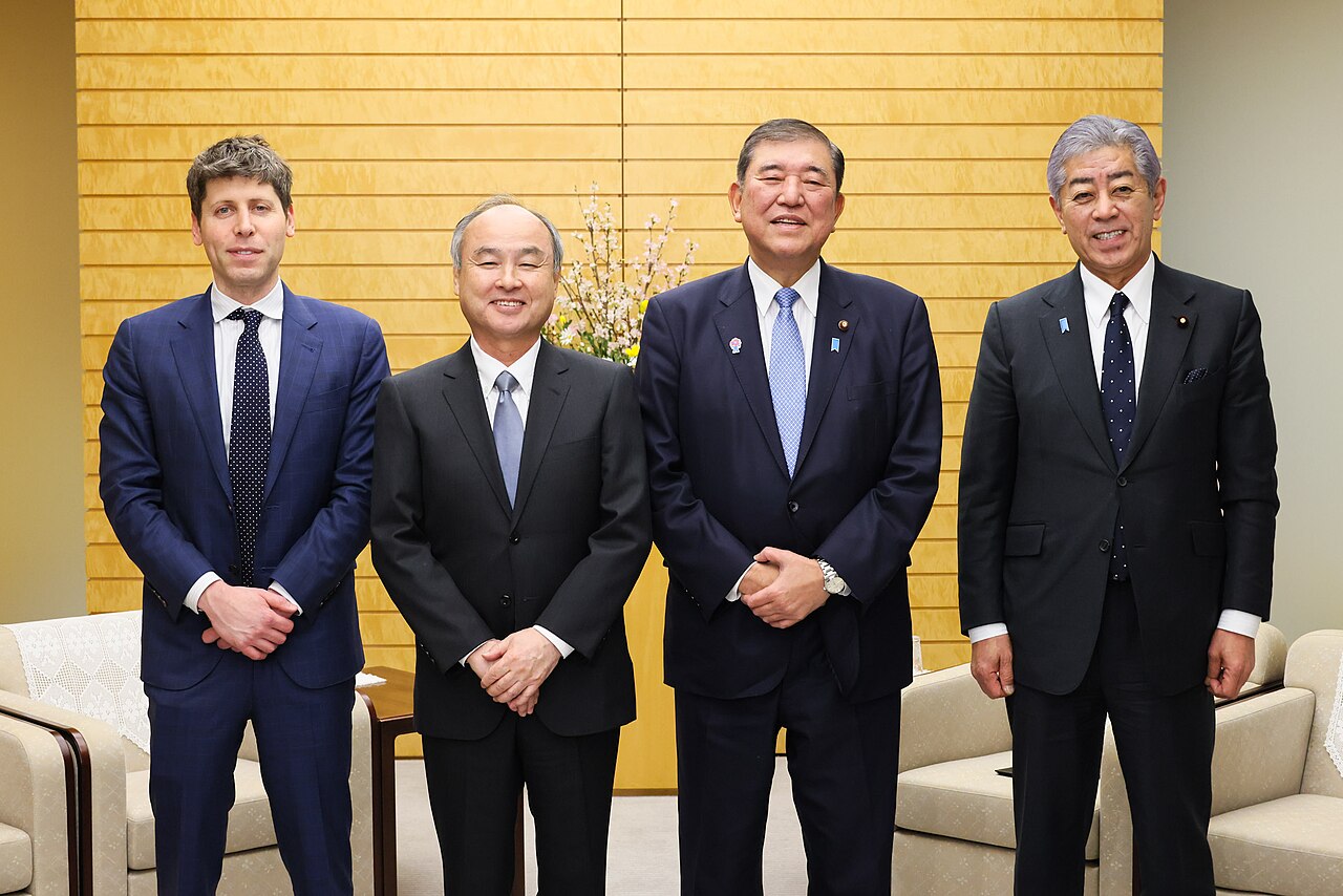 Sam Altman and Masayoshi Son standing with Japanese officials at the Prime Minister's Office