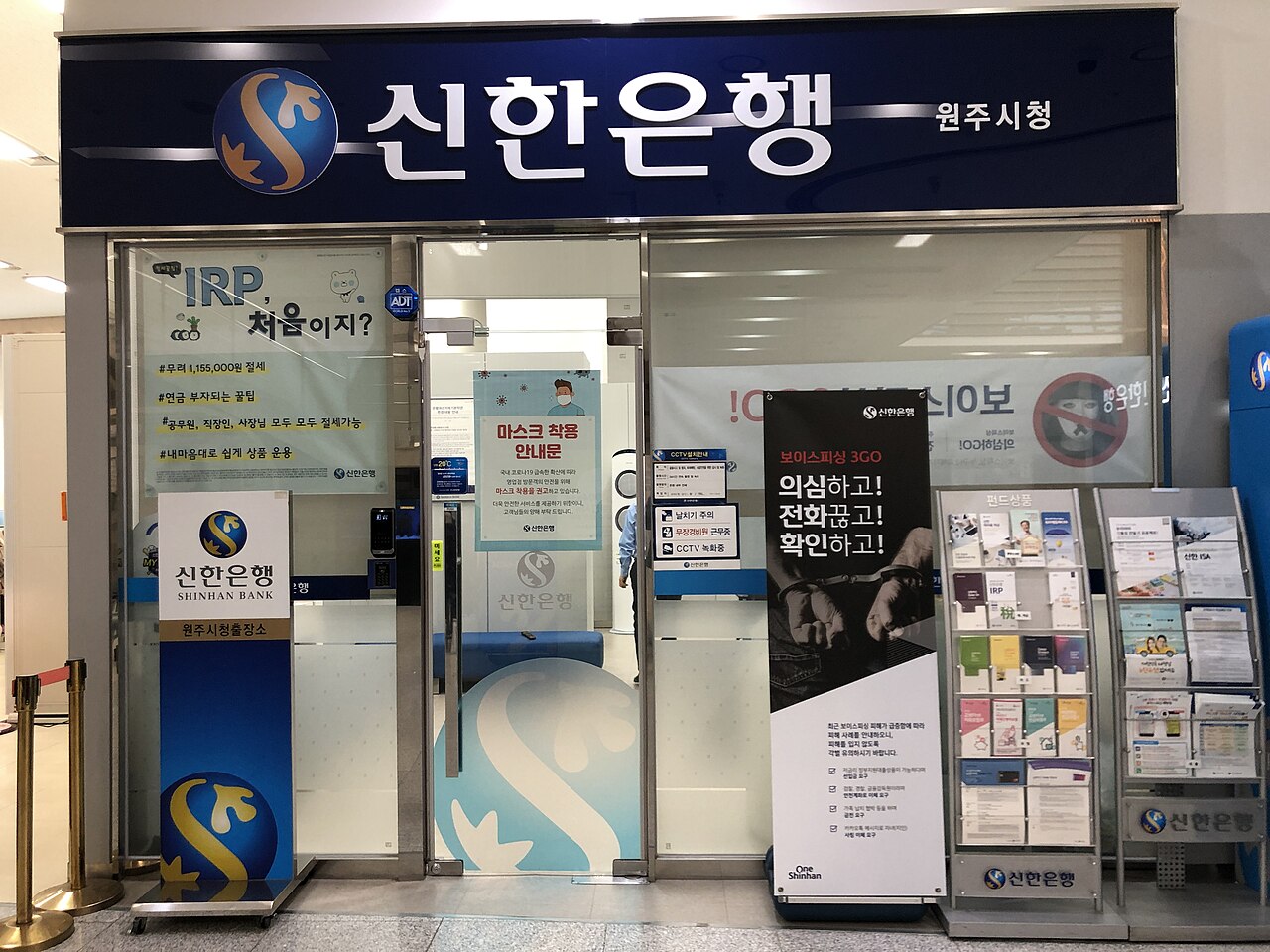 Front of a Shinhan Bank branch at Wonju City Hall in South Korea, with a voice phishing warning banner beside the entrance