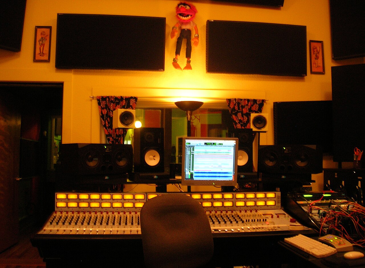 Professional recording studio control room with a mixing console, monitors and a digital audio workstation screen