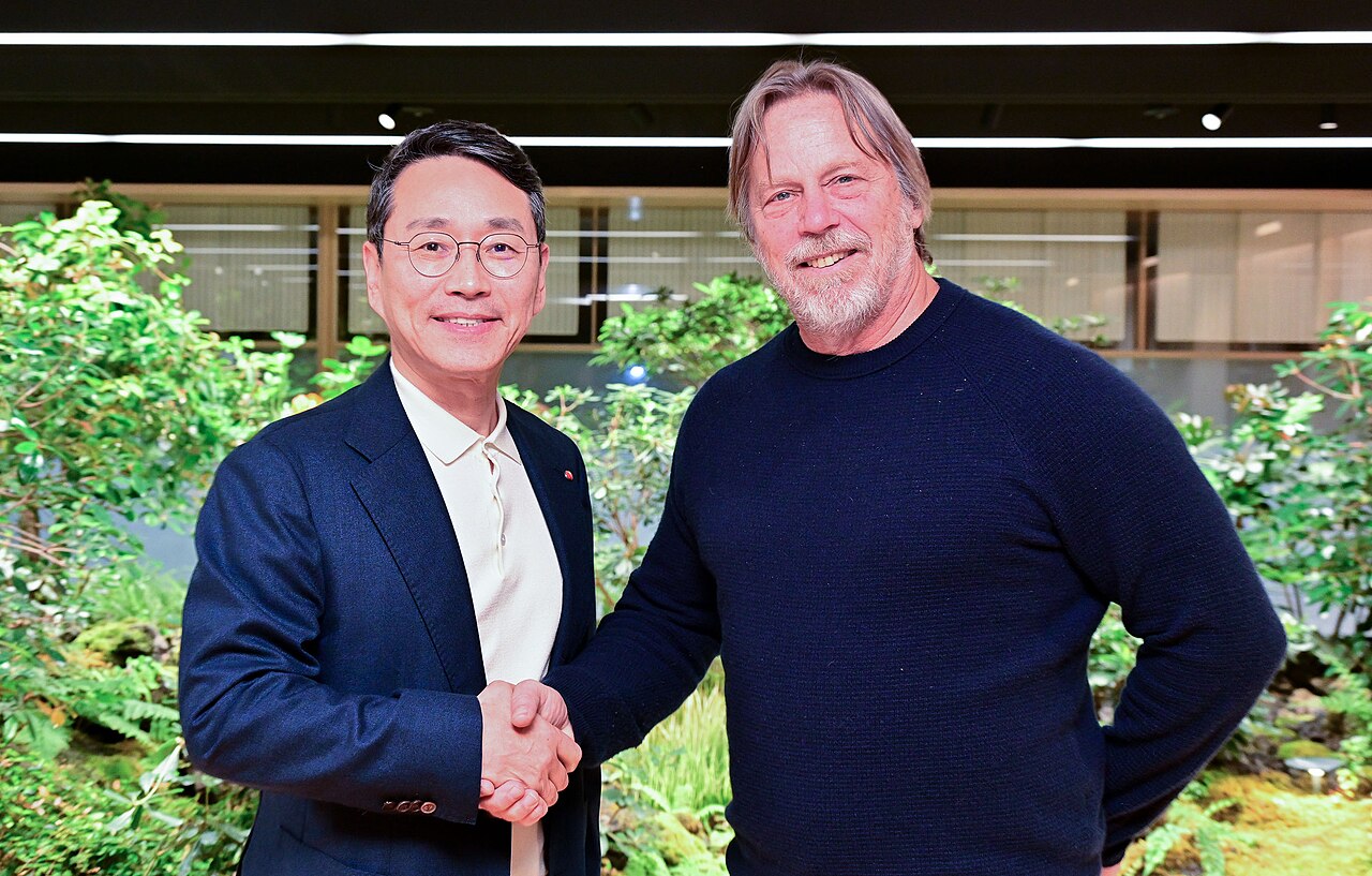 Two men shaking hands in front of an indoor garden at an announcement of LG Electronics' collaboration with Tenstorrent