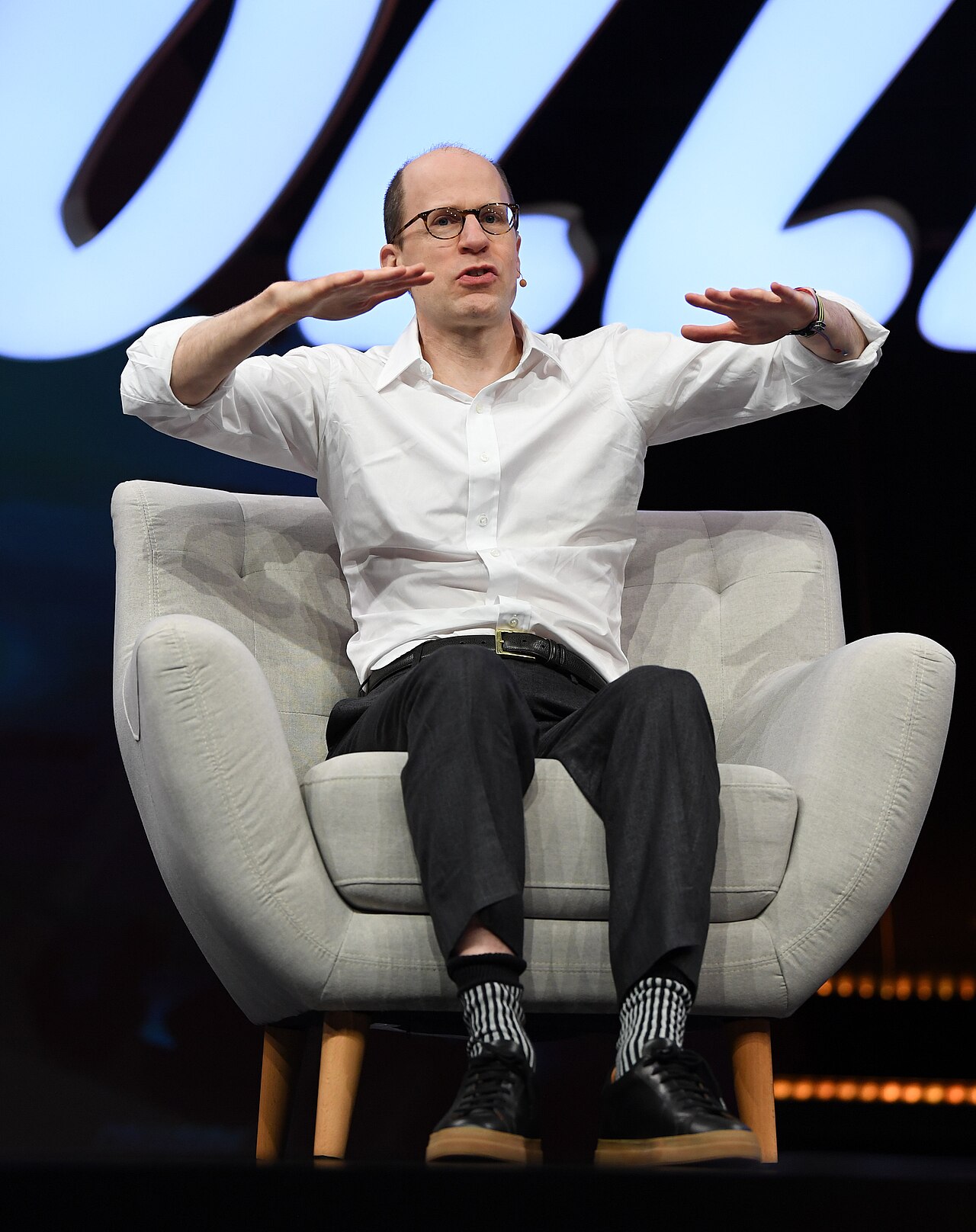 Philosopher Nick Bostrom gesturing while speaking on stage in an armchair