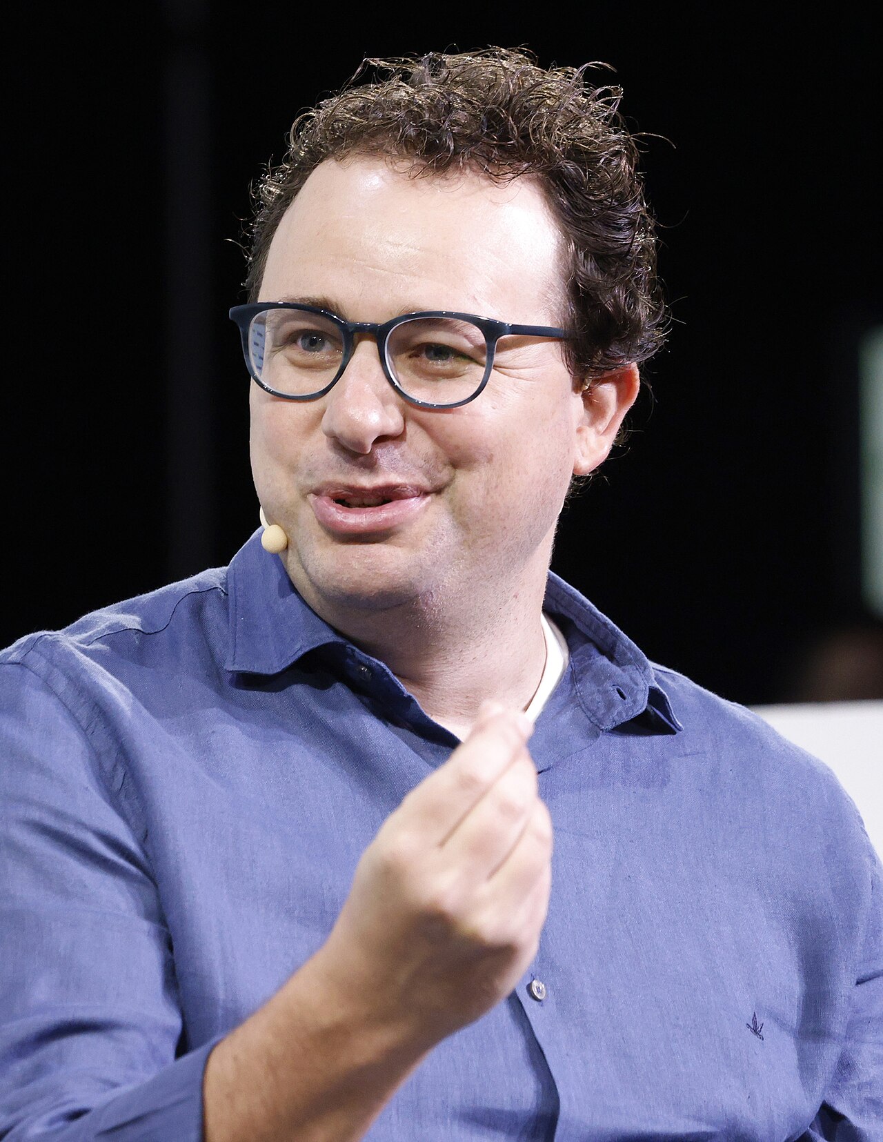 Portrait of Dario Amodei, co-founder and CEO of Anthropic, speaking on stage