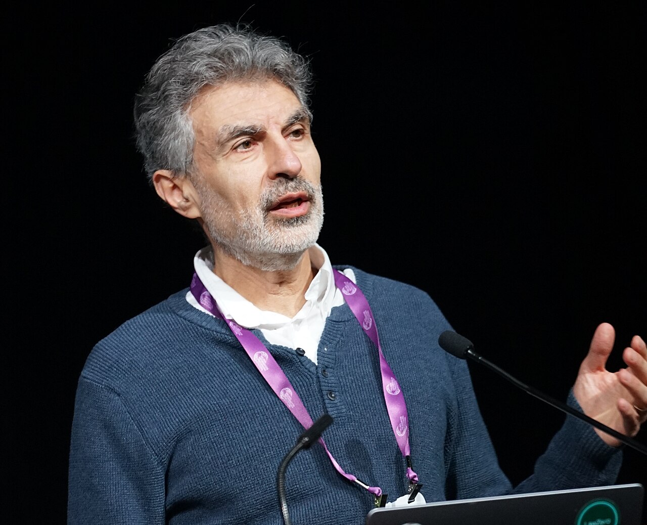 Yoshua Bengio speaking at a conference podium