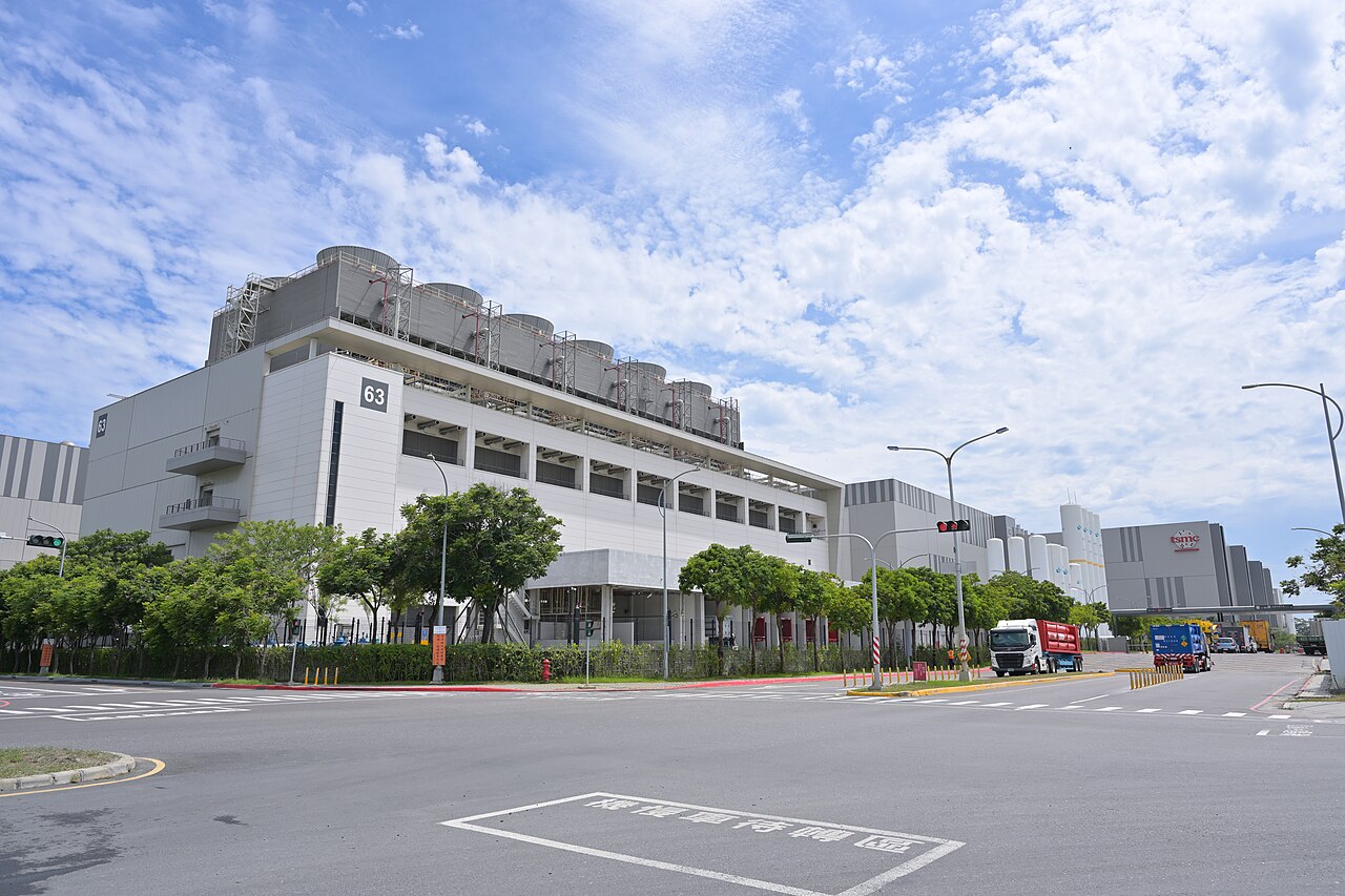 Exterior of a large TSMC semiconductor fabrication plant in Taiwan under a blue sky