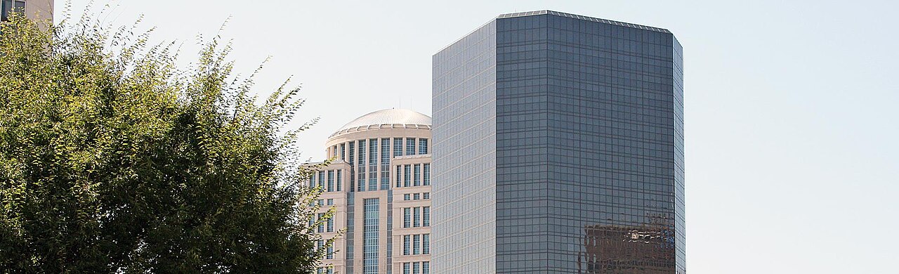 The domed tower and a glass office tower of the Thomas F. Eagleton U.S. Courthouse in St. Louis under a clear sky